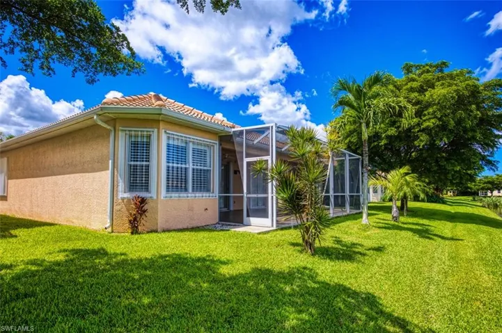 Back of house featuring a lawn and a lanai