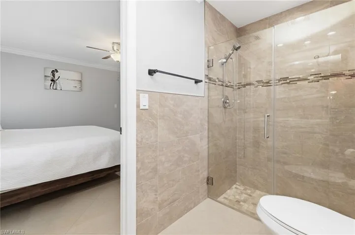 Full bath featuring ensuite bath, a stall shower, and a ceiling fan
