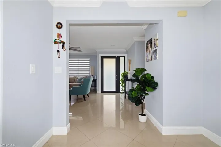 Hall featuring crown molding and light tile patterned floors