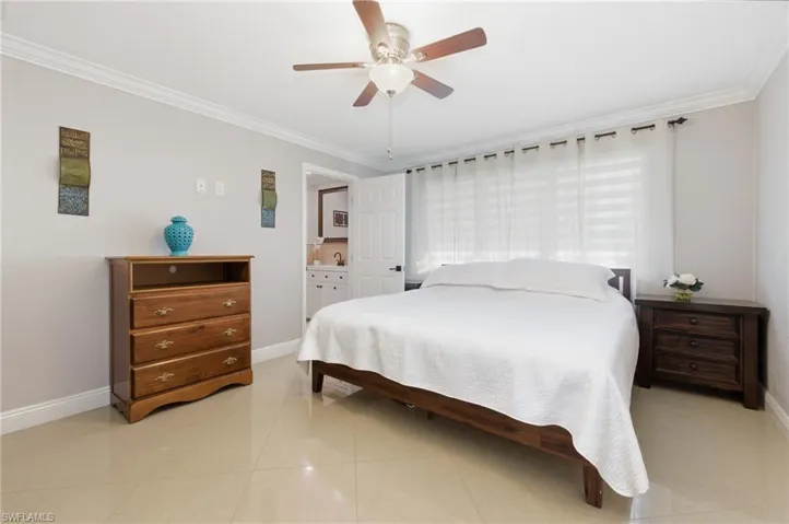 Bedroom featuring ornamental molding, ceiling fan, and light tile patterned flooring