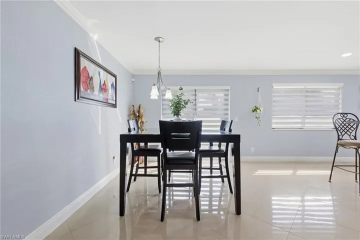 Dining space featuring crown molding and light tile patterned floors