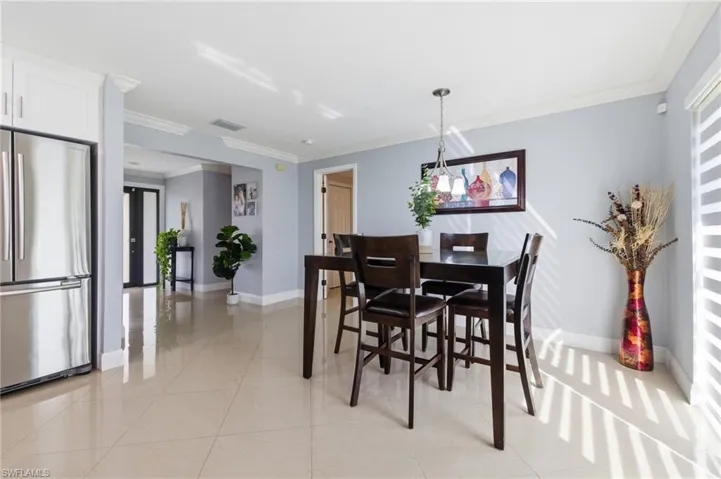 Dining room with ornamental molding and light tile patterned flooring