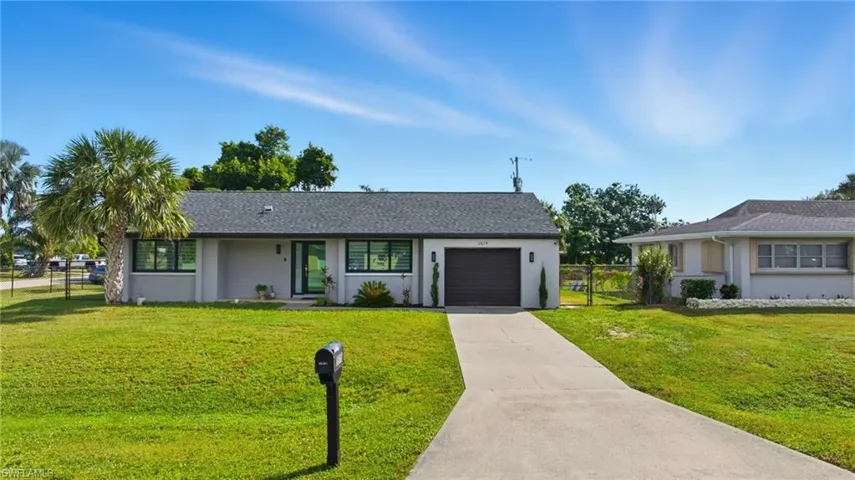 View of front facade featuring stucco siding, concrete driveway, a garage, and roof with shingles