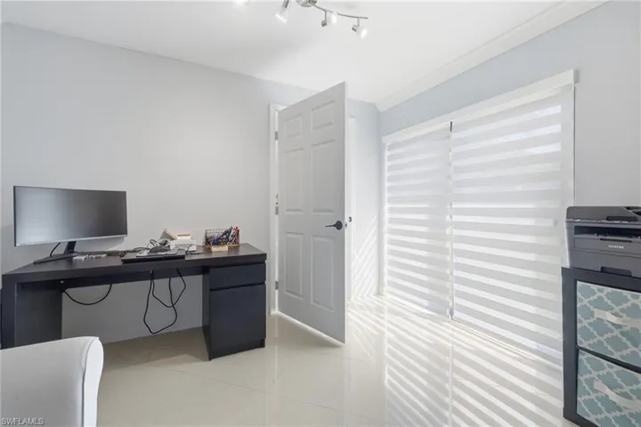 Home office with light tile patterned flooring and ornamental molding