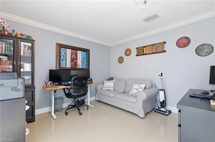 Home office with ornamental molding and light tile patterned floors