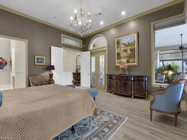 Primary Bedroom with French doors, crown molding, suspended lighting, and access to outside