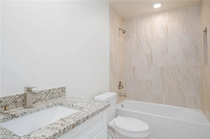 Full bathroom with vanity, toilet, and tiled shower / bath