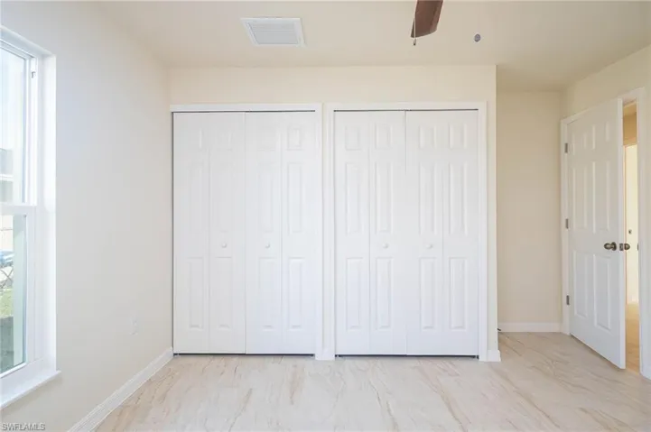 Unfurnished bedroom featuring two closets and ceiling fan