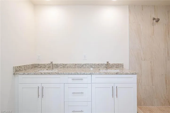 Bathroom with vanity and tiled shower