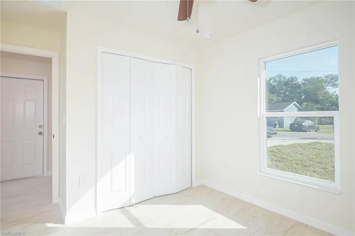 Unfurnished bedroom with ceiling fan and a closet