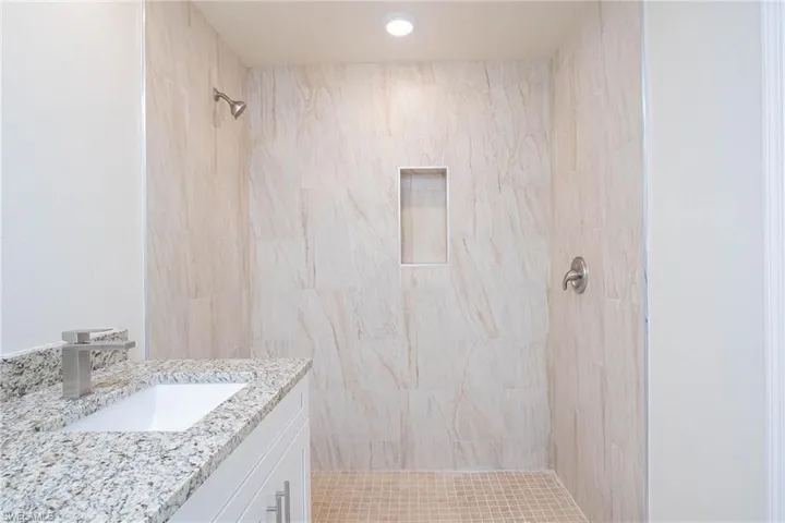 Bathroom featuring vanity and tiled shower