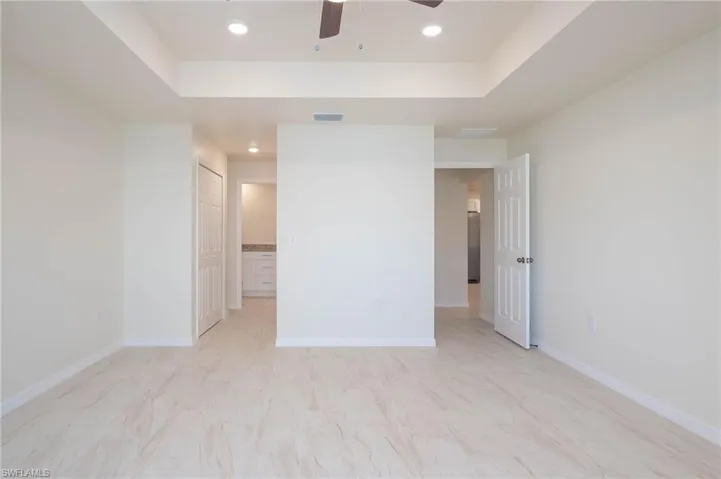 Empty room featuring ceiling fan and a raised ceiling