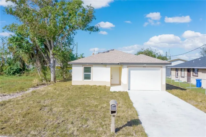 View of front of house with a front lawn and a garage