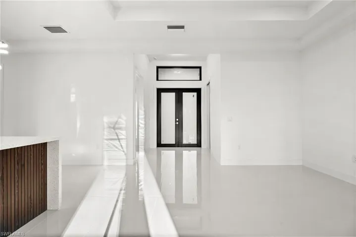Empty room featuring french doors and concrete floors