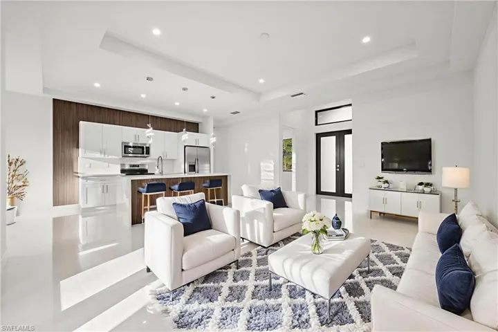 Living area featuring light tile patterned floors, recessed lighting, and a raised ceiling
