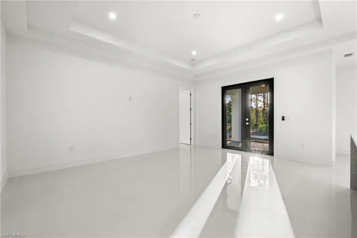 Spare room featuring french doors, a tray ceiling, and recessed lighting