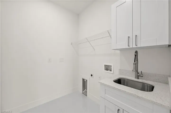 Laundry room with electric dryer hookup, cabinet space, hookup for a washing machine, and light tile patterned flooring
