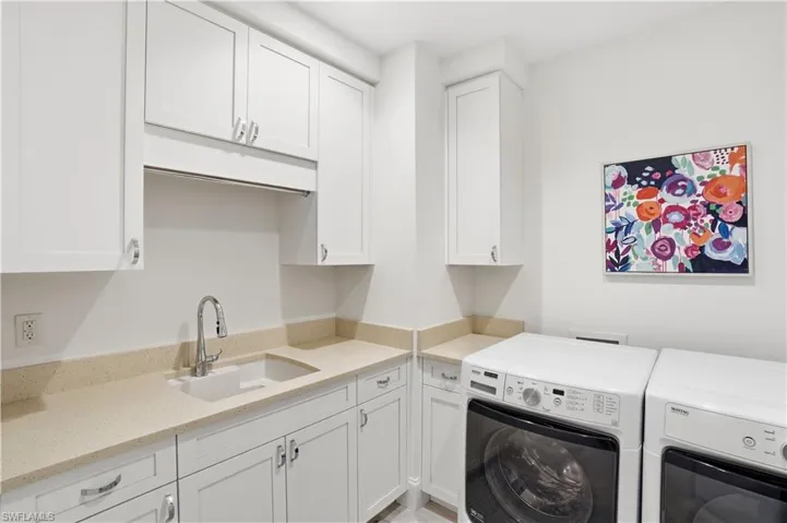 Laundry room with ample storage and sink.