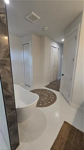 Bathroom featuring a soaking tub, a closet, and recessed lighting