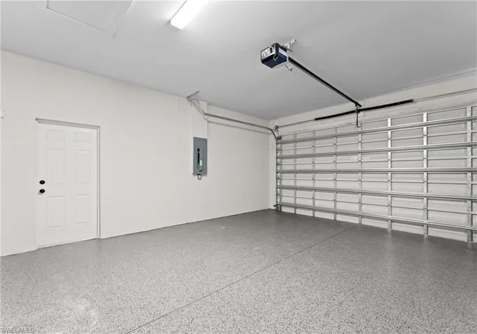 Garage featuring electric panel and a garage door opener