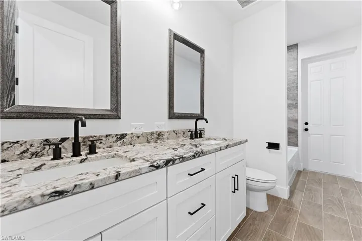 Bathroom featuring double vanity and  shower combination