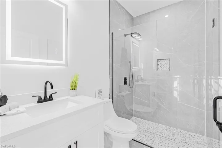 Full bath featuring vanity and a marble finish shower