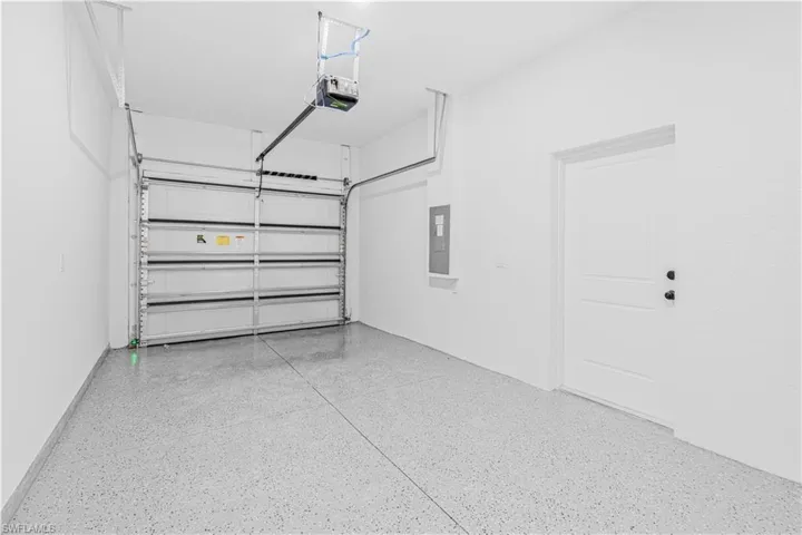 Garage featuring electric panel and a garage door opener
