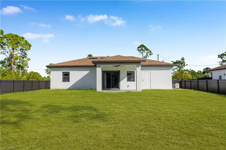 Back of property with a fenced backyard, a patio, stucco siding, and a ceiling fan