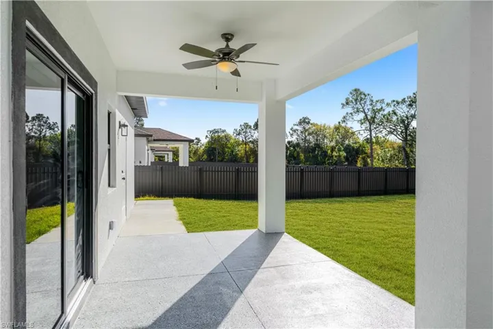 Fenced backyard featuring a patio and a ceiling fan