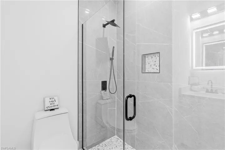 Full bath featuring toilet and a marble finish shower