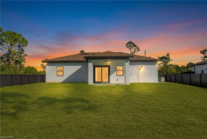 Rear view of house featuring a fenced backyard, stucco siding, a patio, and a shingled roof