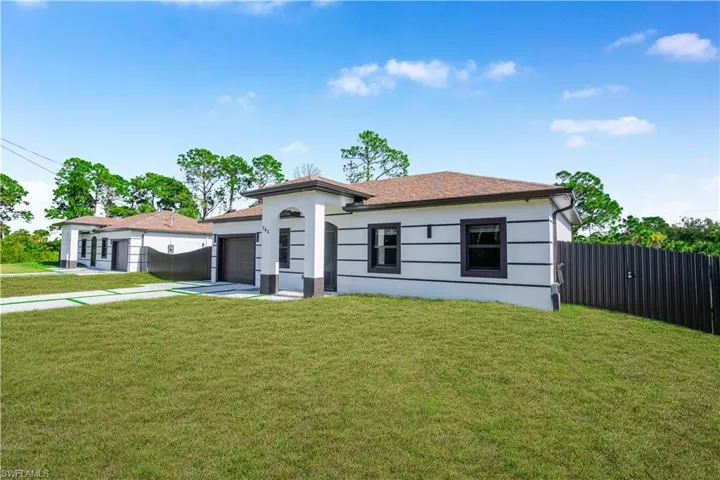 View of front of property featuring a garage, driveway, and stucco siding