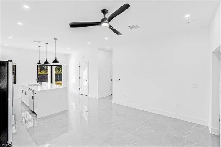 Unfurnished living room with recessed lighting, ceiling fan, and light marble finish floors