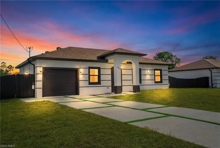 View of front of home featuring concrete driveway, an attached garage, stucco siding, and a shingled roof