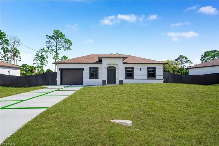 View of front of property featuring driveway, an attached garage, and stucco siding