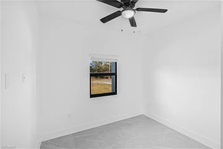 Unfurnished room with baseboards and ceiling fan