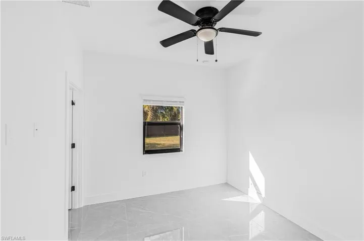 Unfurnished room featuring baseboards and ceiling fan