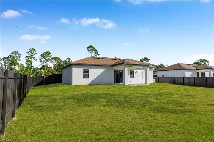 Rear view of property featuring a fenced backyard and stucco siding