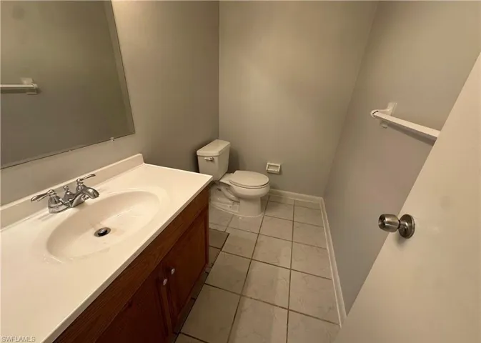 Half bathroom featuring vanity and light tile patterned floors
