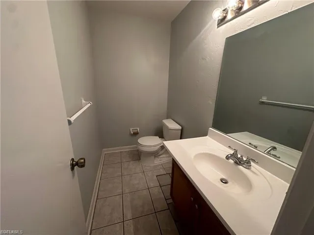 Bathroom with dark tile patterned flooring and vanity