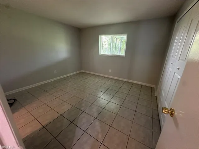 Unfurnished bedroom featuring light tile patterned floors and a closet