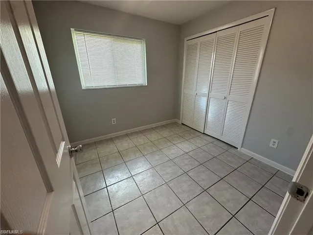 Unfurnished bedroom with light tile patterned flooring and a closet