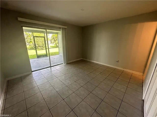 Unfurnished room featuring light tile patterned floors and baseboards