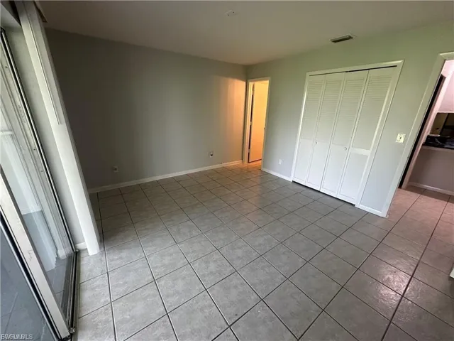 Unfurnished bedroom with light tile patterned flooring and a closet