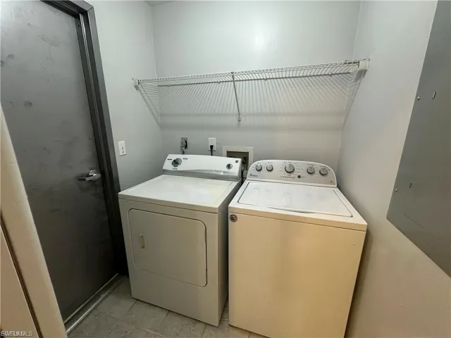 Laundry area featuring electric panel and washer and dryer