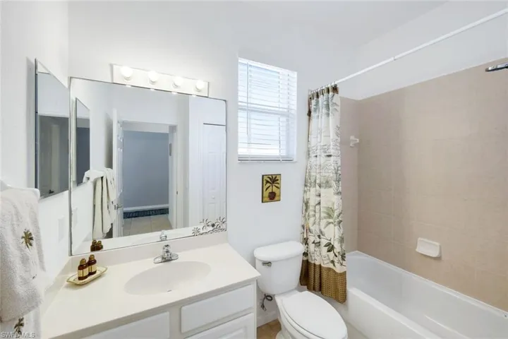 Full bathroom with shower / bath combination with curtain and vanity