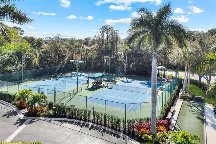View of tennis court with a patio