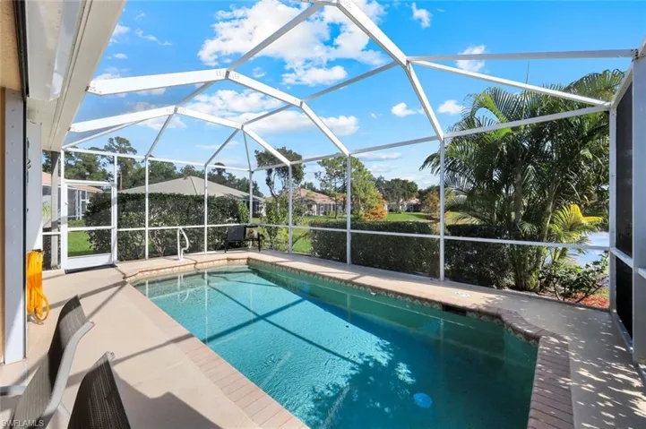 Outdoor pool with a sunroom, a patio area, and glass enclosure