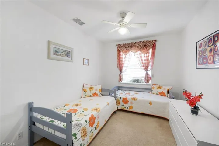 Bedroom with a ceiling fan and light colored carpet
