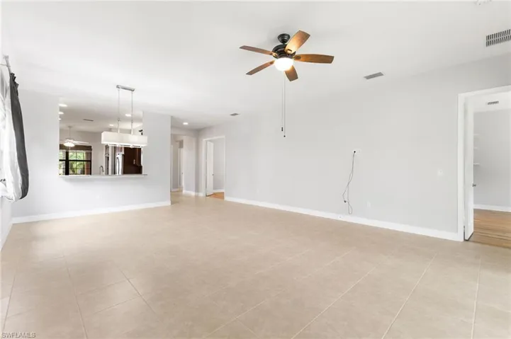 Unfurnished living room featuring light tile patterned floors and ceiling fan